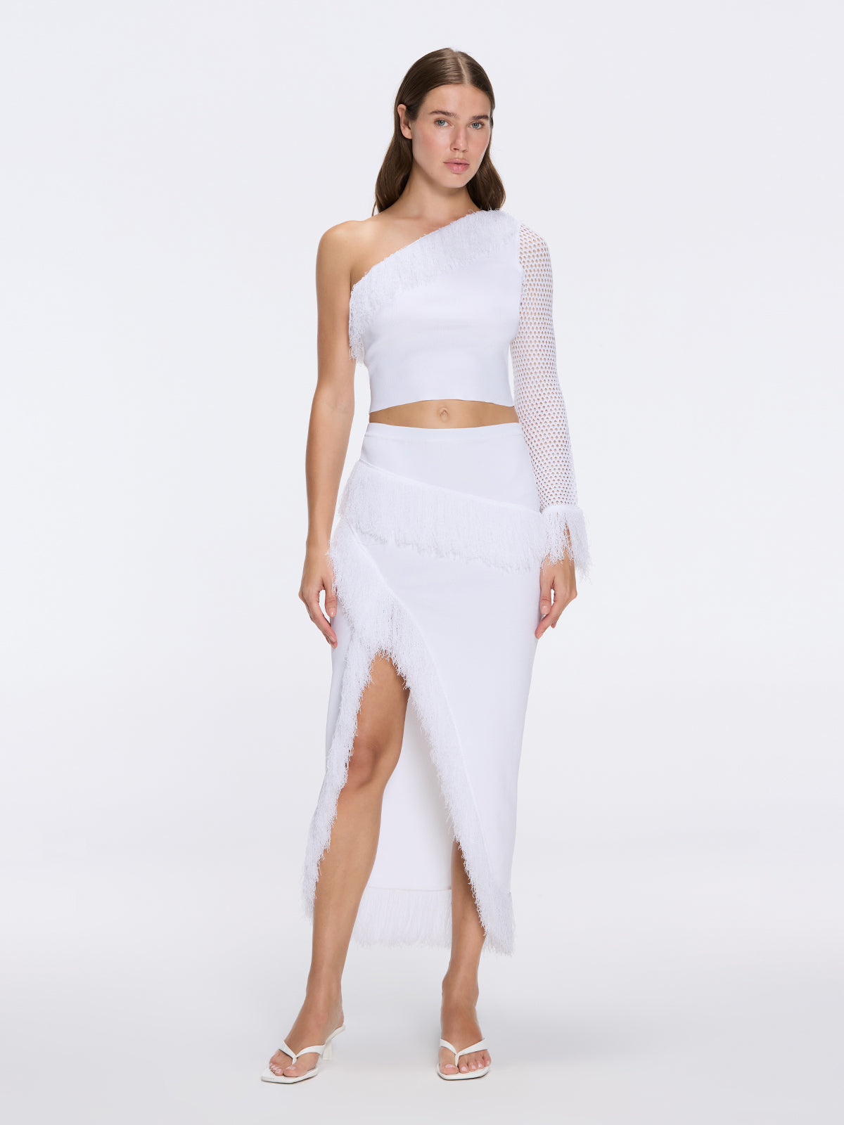 Monroe White One-Shoulder Knit Top with Fringe & Mesh Sleeve | Moeva | Crop Top | Each week unveils new pieces—luxury swimwear, fluid resort silhouettes, and elevated summer-to-evening essentials designed to carry you from coastal escapes to city nights.