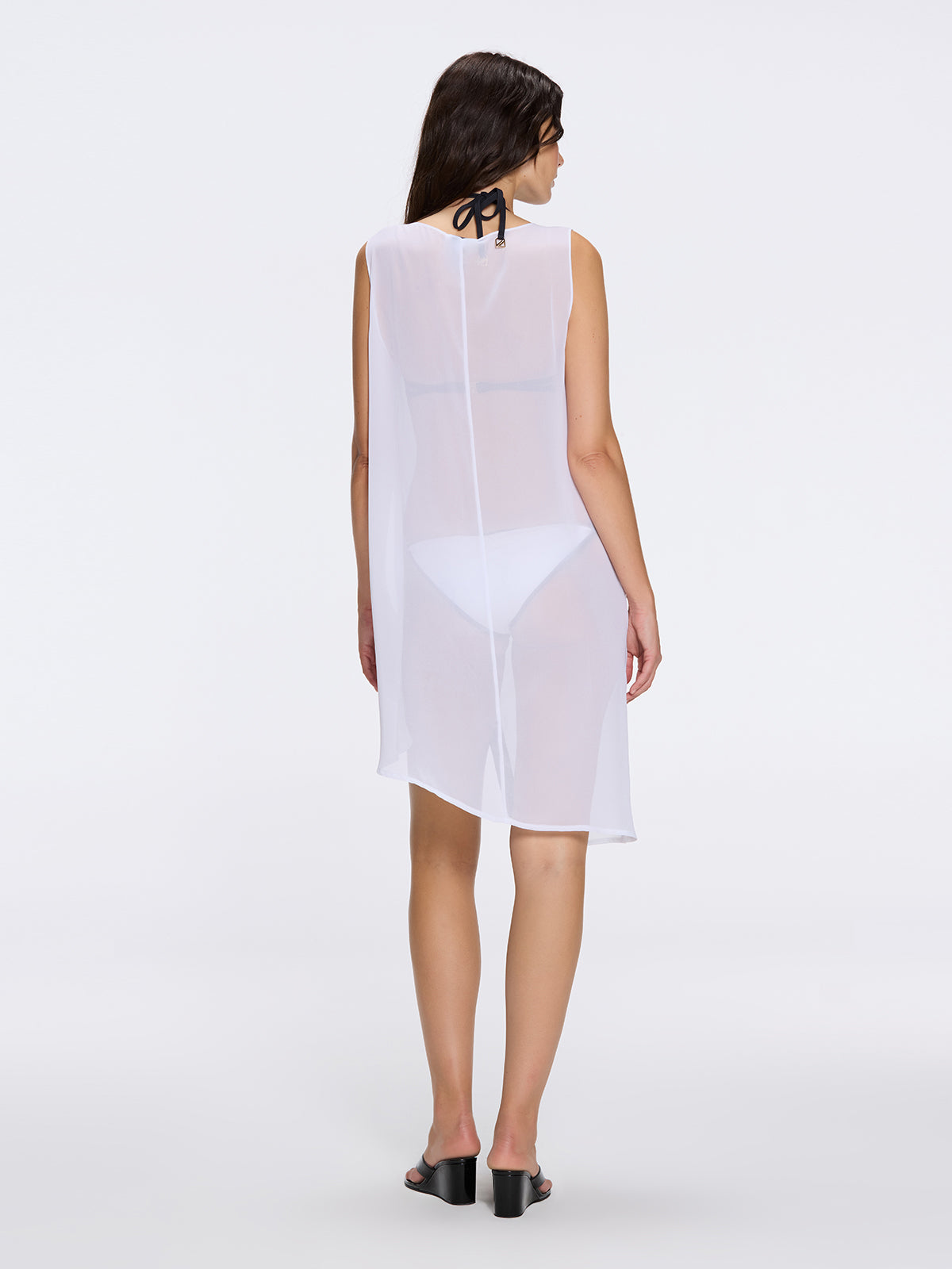 Solianne White Sheer Sleeveless Asymmetric Dress with Gold Button Detail | Moeva | Dress | Each week unveils new pieces—luxury swimwear, fluid resort silhouettes, and elevated summer-to-evening essentials designed to carry you from coastal escapes to city nights.