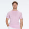 Man wearing a pink short-sleeve shirt and white pants on a white background