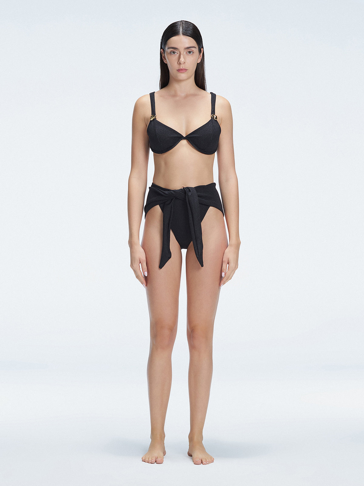 "Model wearing the Dylan Black Bikini Bottom with a high-leg silhouette, showcasing its sleek design by the pool."
