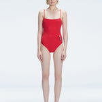 "Model wearing the Marigold Red Swimsuit from the Synersphere SS25 collection, with a square neckline and boned torso."
