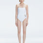 "Model wearing the Marigold White Swimsuit from the Synersphere SS25 collection, with a square neckline and boned torso."
