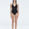 Front view of model wearing Miley BlackOne Piece swimsuit with halter neck and twisted gold accessory.
