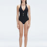 Front view of model wearing Miley BlackOne Piece swimsuit with halter neck and twisted gold accessory.
