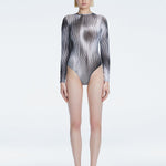 Front view of model wearing Mireya Black Optical Bodysuit with long sleeves and bold optical print.
