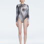 Front view of model wearing Mireya Black Optical Bodysuit with long sleeves and bold optical print.
