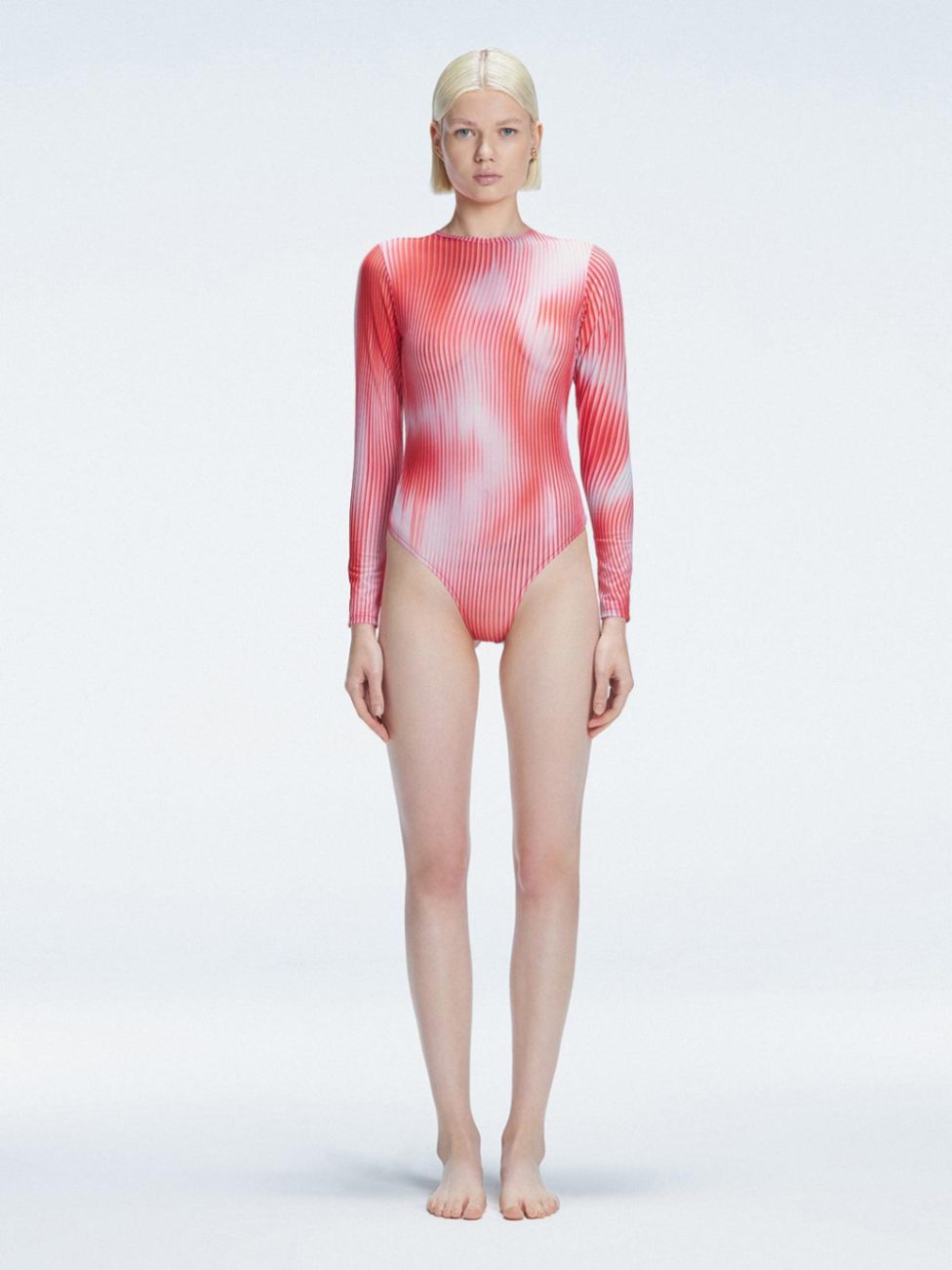 Front view of model wearing Mireya Red Optical Bodysuit with long sleeves and bold optical print.
