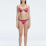 Front view of model wearing Rory Pink Optical Bikini Bottom with low-rise fit and adjustable side ties.
