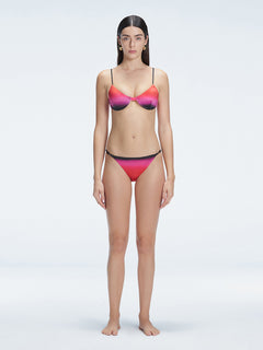 Front view of model wearing Rory Pink Optical Bikini Bottom with low-rise fit and adjustable side ties.
