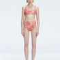 Front view of model wearing Rosalind Red Optical Bikini Bottom with high-waisted design and two-layered tulle.
