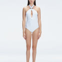 Front view of model wearing Rosamund White One Piece swimsuit with halter neck and gold sculpted hoop accessory.
