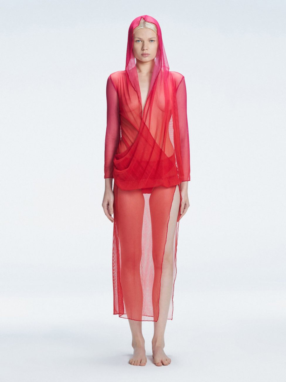 Model wearing the Rosie Red Sonar Dress, showcasing the hooded silhouette and vibrant red-pink color.