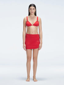 Front view of model wearing Siena Red Mini Skirt with buckle detail and two-layered design.
