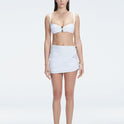 Front view of model wearing Siena White Mini Skirt with buckle detail and two-layered design.
