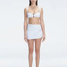 Front view of model wearing Siena White Mini Skirt with buckle detail and two-layered design.
