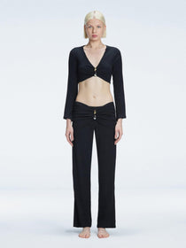 Front view of model wearing Helena Black Pants with mid-rise V-shaped waistline, wide-legged cut, and buckle detail.
