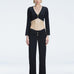 Front view of model wearing Helena Black Pants with mid-rise V-shaped waistline, wide-legged cut, and buckle detail.
