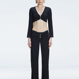 Front view of model wearing Sirenia Black Crop Top and Helena Pants with V-neck, long sleeves, and buckle detail.
