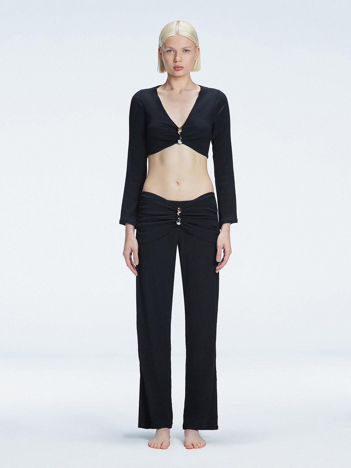 Front view of model wearing Sirenia Black Crop Top and Helena Pants with V-neck, long sleeves, and buckle detail.
