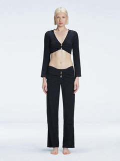 Front view of model wearing Sirenia Black Crop Top and Helena Pants with V-neck, long sleeves, and buckle detail.
