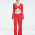 Front view of model wearing Helena Red Pants with mid-rise V-shaped waistline, wide-legged cut, and buckle detail.
