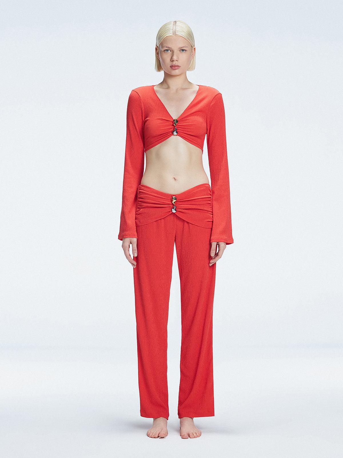 Front view of model wearing Helena Red Pants with mid-rise V-shaped waistline, wide-legged cut, and buckle detail.
