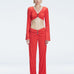 Front view of model wearing Sirenia Red Crop Top and Helena Pants  with V-neck, long sleeves, and buckle detail.
