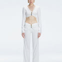 Front view of model wearing Helena White Pants with mid-rise V-shaped waistline, wide-legged cut, and buckle detail.
