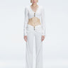 Front view of model wearing Helena White Pants with mid-rise V-shaped waistline, wide-legged cut, and buckle detail.
