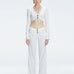 Front view of model wearing  Sirenia White Crop Top and Helena Pants   with V-neck, long sleeves, and buckle detail.
