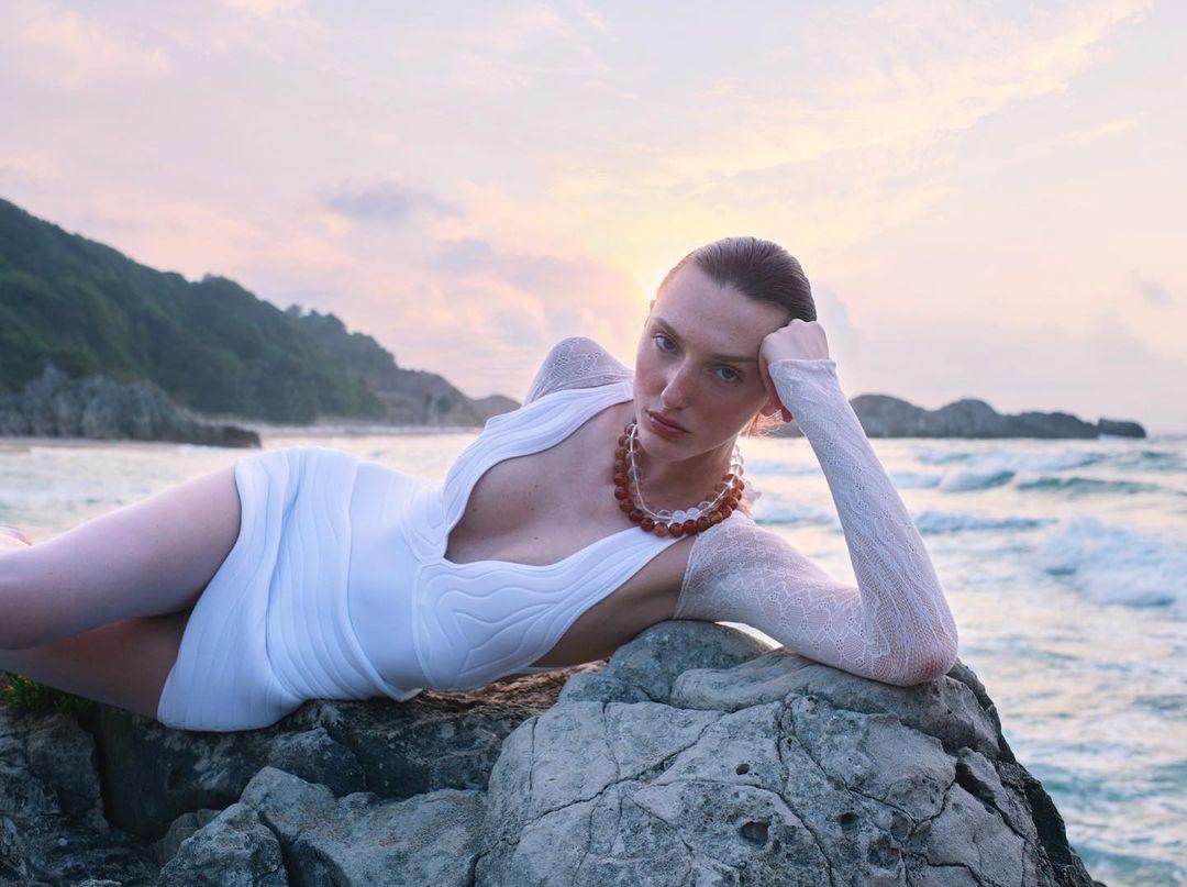 Model wearing the Breena White Swimsuit paired with the Ephram White Skirt, featured in Sober Magazine.
