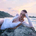 Model wearing the Breena White Swimsuit paired with the Ephram White Skirt, featured in Sober Magazine.
