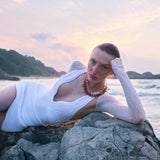 Model wearing the Breena White Swimsuit paired with the Ephram White Skirt, featured in Sober Magazine.
