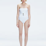 Front view of model wearing Ursula White One Piece swimsuit with strapless silhouette and twisted gold accessory.
