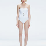 Front view of model wearing Ursula White One Piece swimsuit with strapless silhouette and twisted gold accessory.
