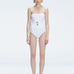 Front view of model wearing Ursula White One Piece swimsuit with strapless silhouette and twisted gold accessory.
