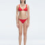 "Model wearing the Zella Red Bikini Set from the front view, featuring a personalized fit with removable padding."
