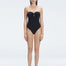 "Model wearing the Zephyrine Black Swimsuit from the front view, featuring removable straps and a chic buckle."
