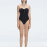 "Model wearing the Zephyrine Black Swimsuit from the front view, featuring removable straps and a chic buckle."
