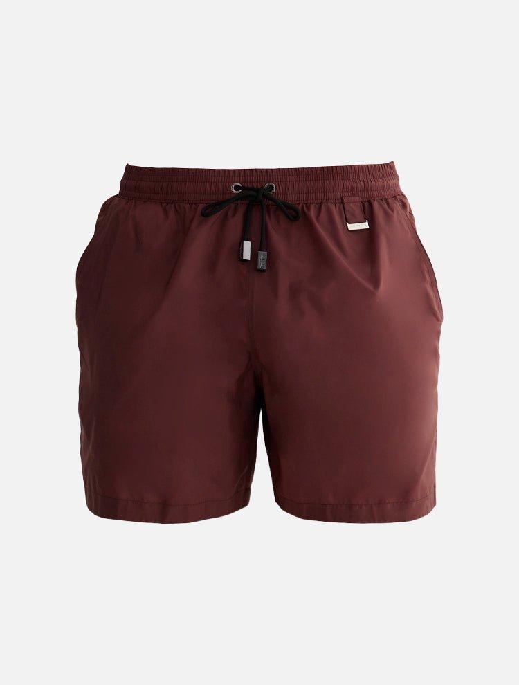  A collage of the Louis Bordeaux mid-thigh length men's swim shorts from various angles. The front view emphasizes the elastic waistband, drawstring with black nickel stoppers, and Moeva patch. The back view showcases the rich bordeaux color and sleek design. The side view highlights the two open side pockets and tailored fit, hinting at the fabric's lightness and quick-dry properties. A close-up focuses on the fabric texture, drawstring details, and craftsmanship. The collage collectively illustrates the s