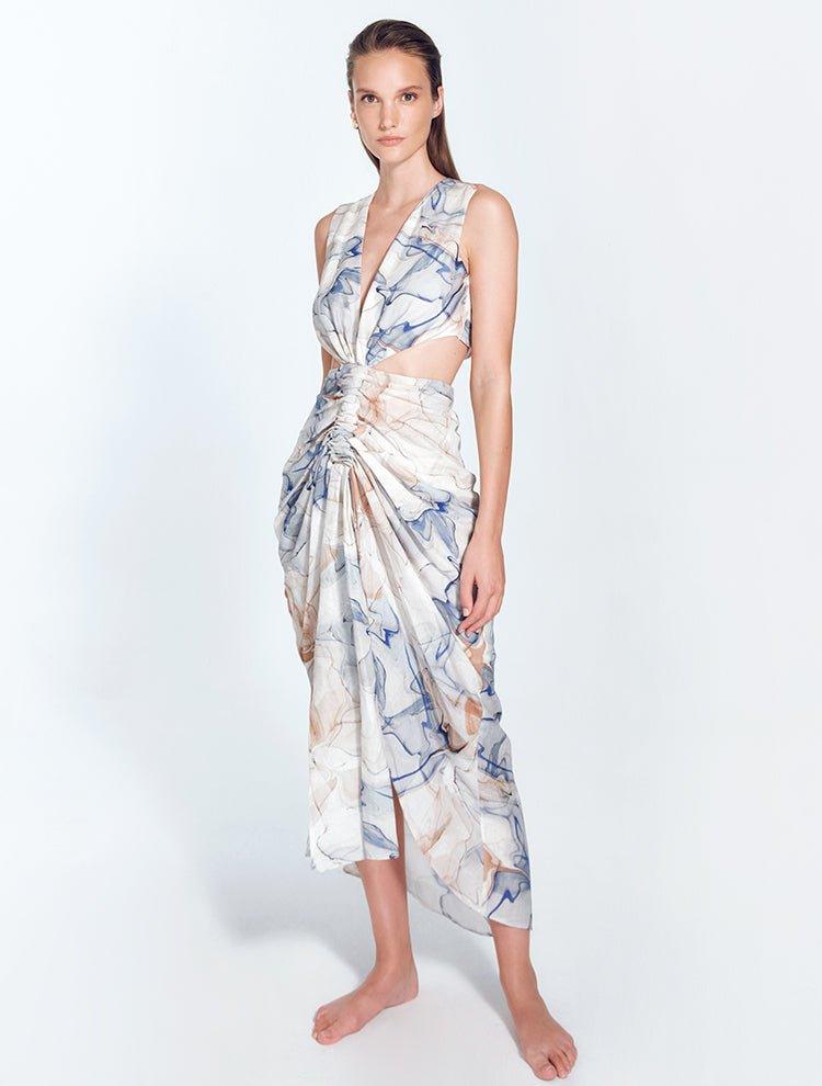  "Front view of Adelice blue abstract dress with deep V neckline, center ruching, asymmetrical skirt, high front slit, and side cutouts."