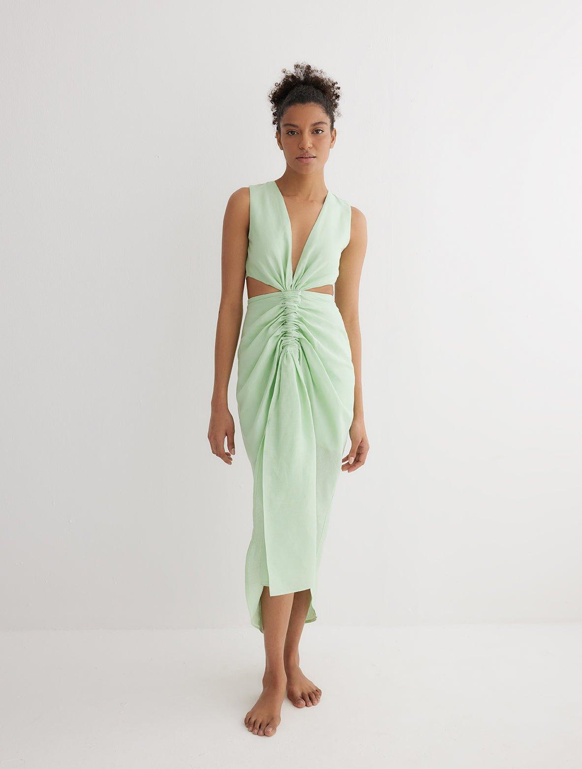"Front view of the Adelice Mint Green Dress featuring a deep V neckline, ruching, high front slit, and asymmetrical skirt."