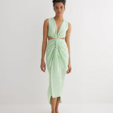 "Front view of the Adelice Mint Green Dress featuring a deep V neckline, ruching, high front slit, and asymmetrical skirt."