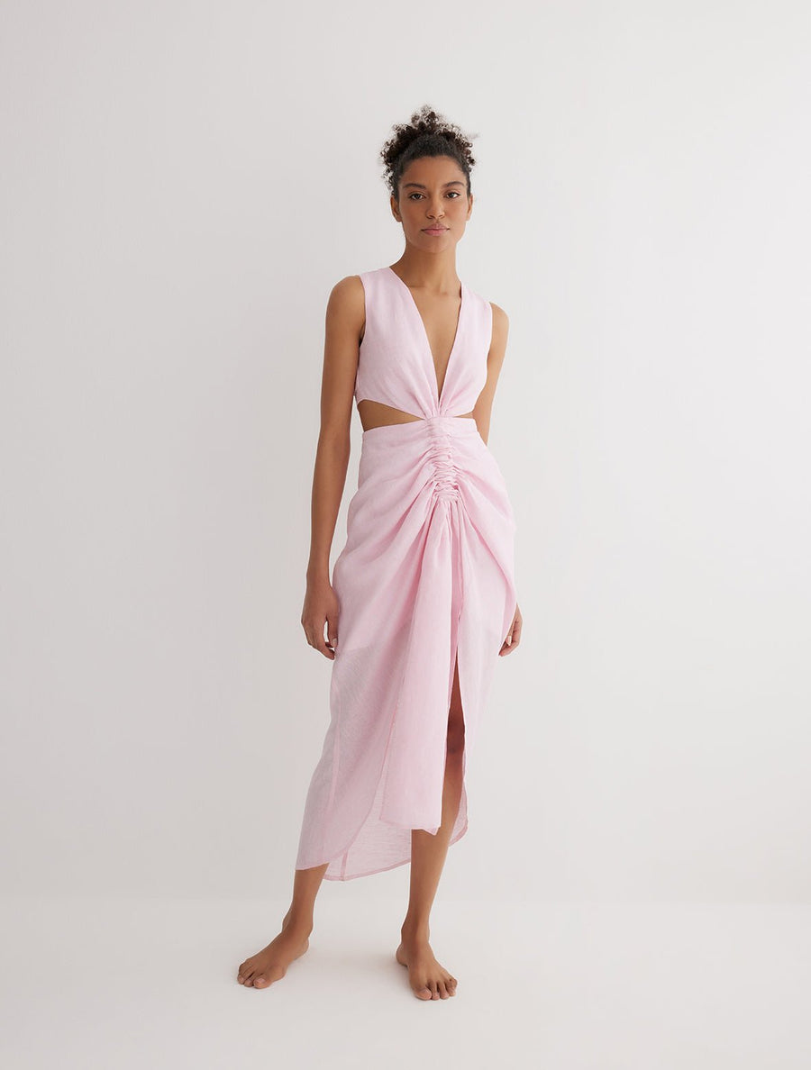 Front View: Model in Adelice Pink Dress - MOEVA Luxury Swimwear, Deep V Neck, Front Slit, Asymmetrical Skirt, Ruching Through the Center, MOEVA Luxury Swimwear