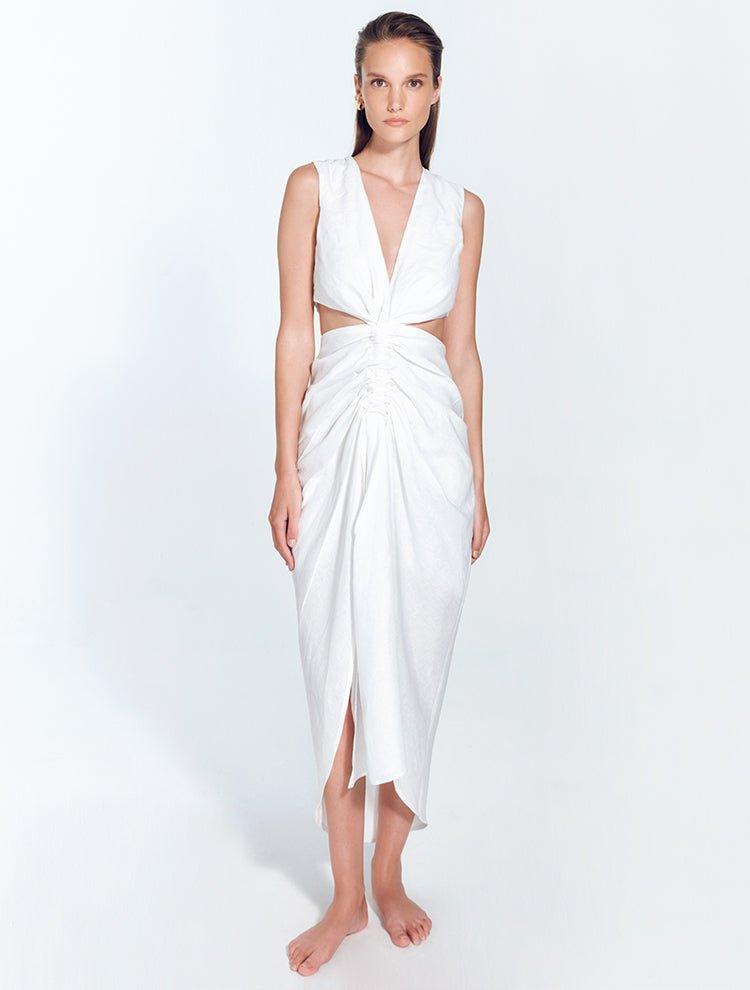 "Front view of Adelice white dress with deep V neckline, center ruching, asymmetrical skirt, high front slit, and side cutouts."