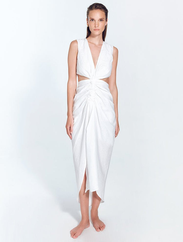 Front View: Model in Adelice White Dress - MOEVA Luxury Swimwear, Deep V Neck, Front Slit, Asymmetrical Skirt, Ruching Through the Center, MOEVA Luxury Swimwear