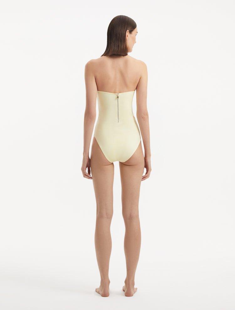 Rear view of the Anahita Yellow Swimsuit, featuring the sporty zip and full bottom coverage.