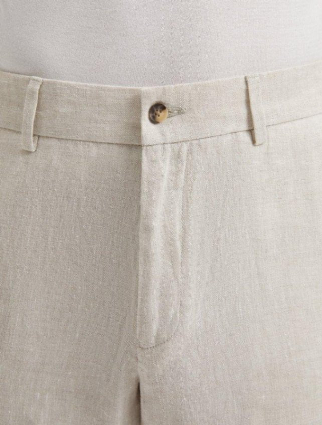 Close-up front view of Adrian Beige Pants on a model, emphasizing the button detailing and streamlined silhouette.