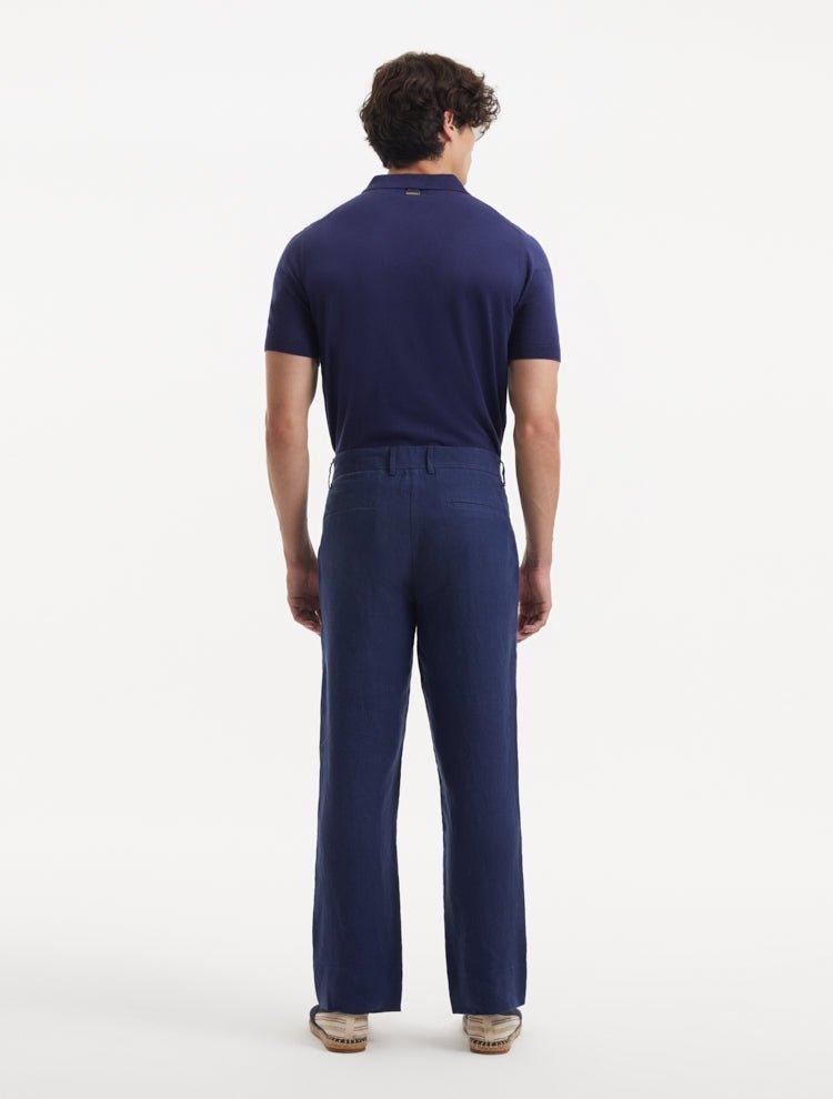 Model displaying Adrian Dark Blue Pants from the back, focusing on the contemporary cut and comfortable fit. The mid-rise waist and functional welt pockets are clearly visible.