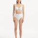 Model wearing the Adva White Bikini Bottom, showcasing the high-waist design and shell accents.